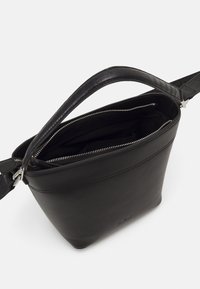 Borsa a tracolla in pelle nera con una forma strutturata, chiusura con zip e manico in pelle con stampa cocco. L'interno è foderato in tessuto nero.