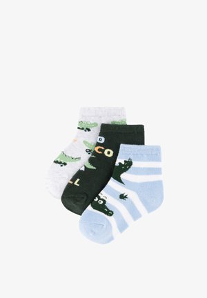 Tres pares de calcetines para niños pequeños con diseños de cocodrilos: blancos con cocodrilos verdes, verde oscuro con texto y azules con rayas blancas y cocodrilos.