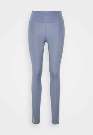 Leggings azules elásticos con una cinturilla alta, textura suave y aberturas en los laterales del dobladillo. Diseñados para la comodidad y el movimiento.
