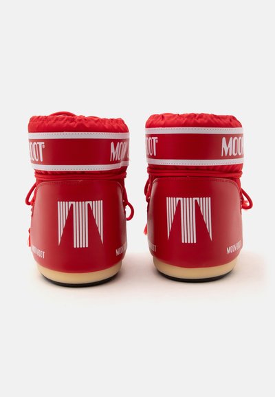 Ζευγάρι κόκκινες χειμερινές μπότες Moon Boot, εμφανιζόμενες από πίσω με λευκές λωρίδες λογότυπου και ανοιχτόχρωμες σόλες σε λευκό φόντο.