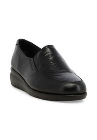 Scarpa nera senza lacci con tomaia in pelle leggermente strutturata e suola liscia, progettata per un uso casual o professionale.