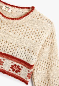 Sweter z dzianiny w kolorze kremowym, z otwartym splotem, czerwonym wykończeniem przy kołnierzu i wzorem kwiatowym na dolnym pasku. Lekki i przewiewny materiał.