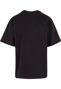 Černé oversized tričko, krátké rukávy, kulatý výstřih, vyrobené z měkké bavlny, s jednoduchým designem bez jakýchkoliv vzorů nebo akcentů.