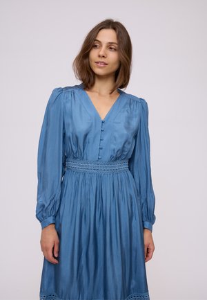 Long-sleeve blue dress with a V-neck, featuring button details and a smocked waist. Made from a smooth, shiny fabric with lace accents.