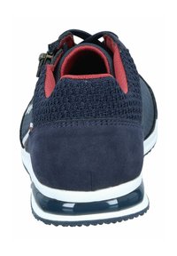 Granatowe buty sportowe z zamszu i materiału dzianinowego; posiadają wyściółkę kołnierza, czerwone akcenty oraz białą podeszwę z przezroczystą sekcją poduszkową.