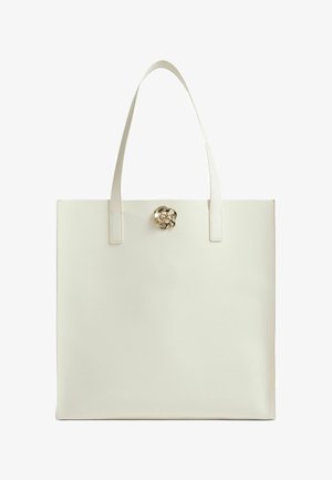 Crèmekleurige tas met twee lange handvatten en een kleine gouden rozenvormige sluiting bovenaan in het midden.