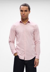 Helles rosa Langarmhemd mit feinen vertikalen Streifen, Button-Down-Kragen und Ein-Knopf-Manschetten. Der Stoff wirkt glatt und knackig.
