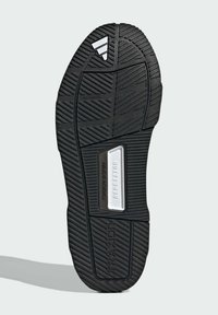 Black rubber sneaker sole featuring a textured tread pattern. Includes a silver accent reading "REPETITOR" and "TRAXION" branding.