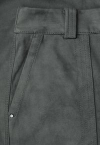 Gray faux suede fabric close-up featuring flat front, stitched detailing, and a small silver button on the pocket. Soft texture.