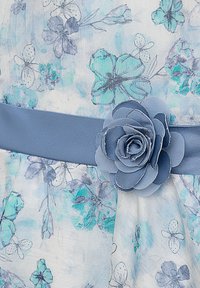 Florales Kleid aus leichtem Stoff mit blauen Blumenmustern, akzentuiert durch einen blauen Stoffgürtel mit 3D-Blumenverzierung.