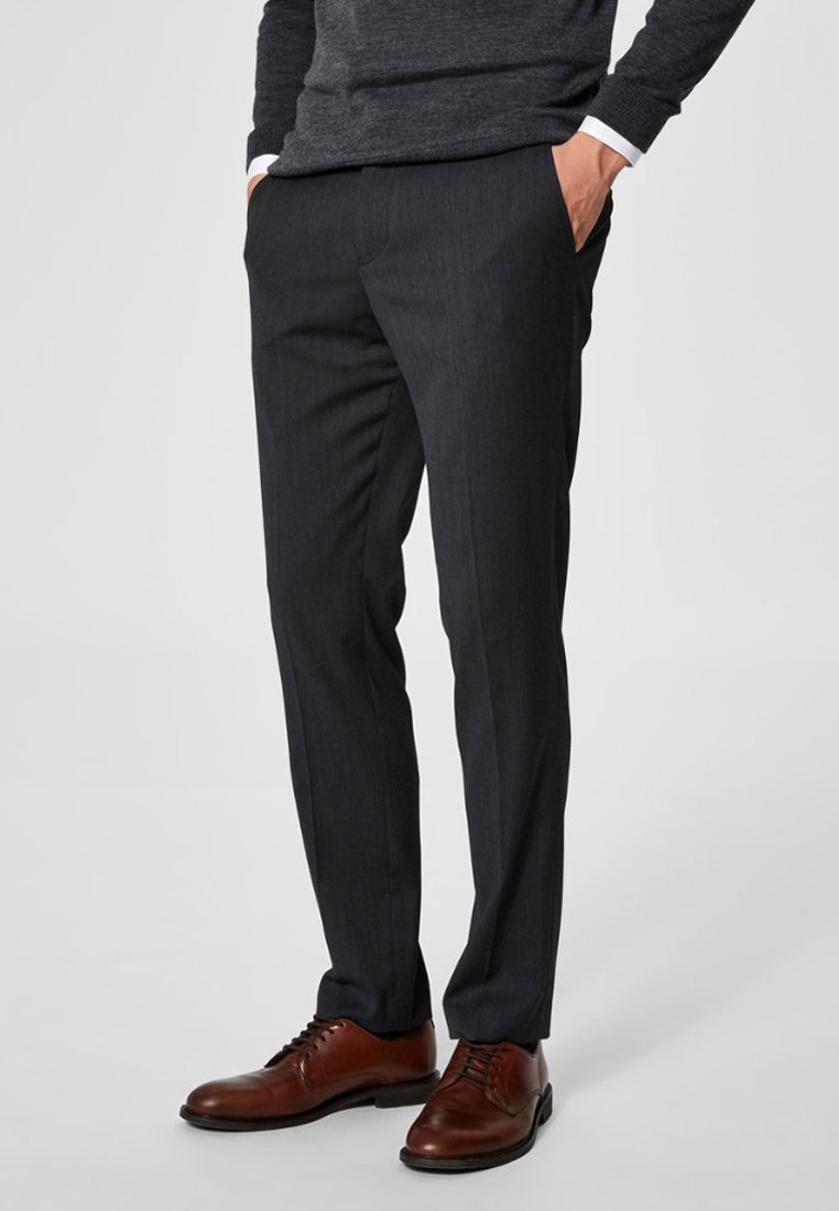 Mørk grå skreddersydde bukser med en glatt tekstur, rett snitt og subtile stripemønster. Brukt med brune lærskjorter.