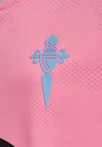 Niebieski herb w kształcie tarczy z koroną, zakończony w szpic, ozdobiony w kształty lilii na różowym, teksturowanym tle.