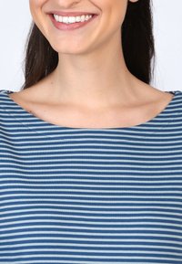 Gestreiftes Oberteil in Blau und Hellblau mit weit geschnittenem Bootsausschnitt, glatter Stoffoberfläche und tailliertem Design, das das Schlüsselbein zur Geltung bringt.