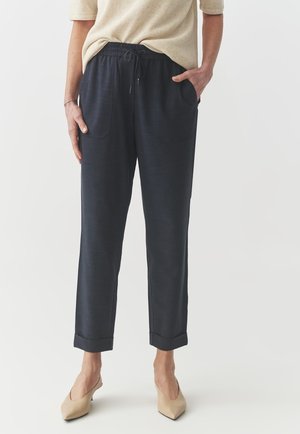 Pantalons de jogging bleu marine foncé en matériau doux, dotés d'une taille élastique, d'un cordon de serrage réglable, de poches latérales et de poignets repliés.