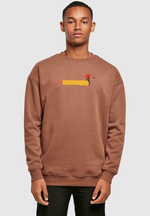 Bruine sweatshirt met een bedrukte teckel in het geel met een rode hoed. Ribgebreide manchetten en zoom, zachte textuur en een relaxte pasvorm.