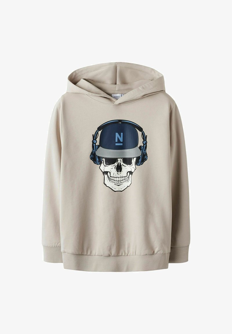 Felpa beige con un grafiche centrale di un teschio che indossa un cappellino blu e cuffie. Il materiale sembra morbido con una vestibilità comoda.