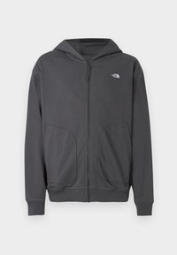 Γκρι φούτερ με φερμουάρ από μαλακό ύφασμα, με τσέπη καγκουρό, ριμπ μανσέτες και μικρό λογότυπο στο αριστερό στήθος.