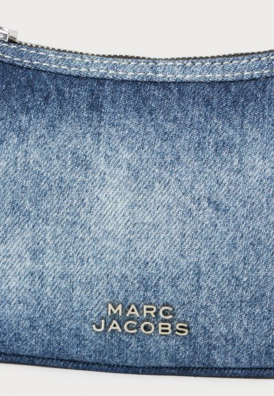 Modrý denimový púzdro so zipsom, s strieborným označením "Marc Jacobs" v dolnej časti. Textúrovaná látka s jemným vyblednutím.