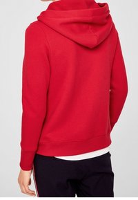 Rød bomulds-hættetrøje med en rummelig hætte, ribbede manchetter og kant. Glat tekstur og casual design, set fra ryggen.