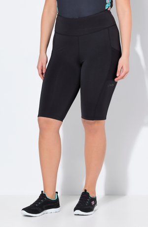 Zwarte sportshorts met een hoge tailleband, een strakke ontwerp en zijpanelen van mesh. Gecombineerd met zwarte sportschoenen met turquoise accenten.