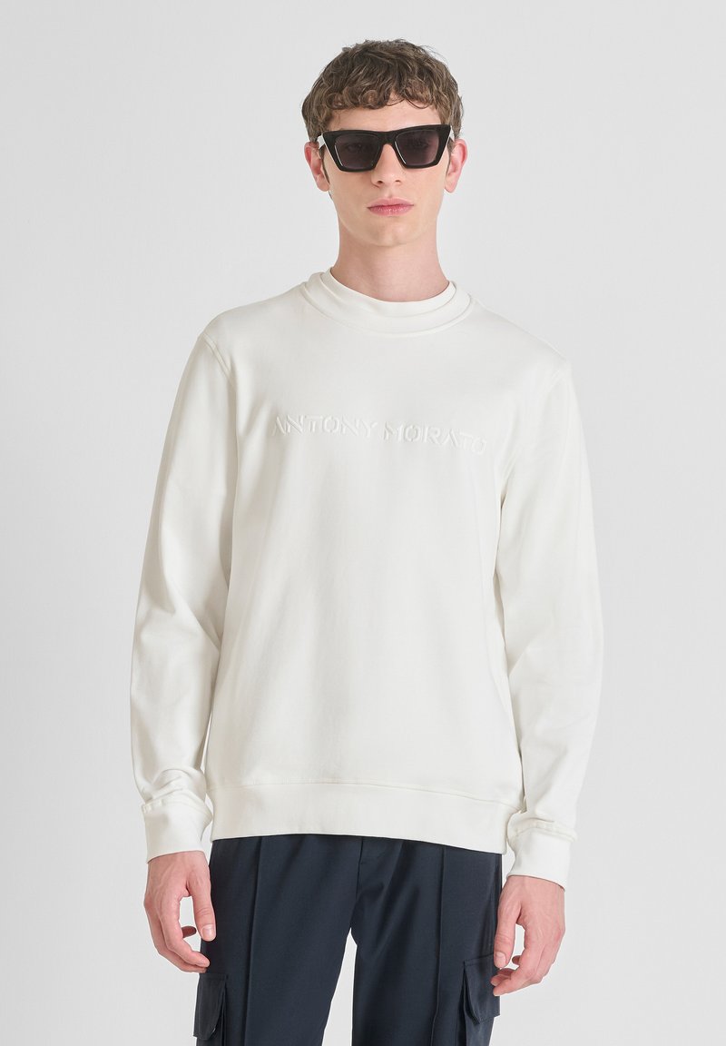 Felpa bianca con logo in rilievo "ANTONY MORATO" sul davanti. Materiale in misto cotone, maniche lunghe, scollatura a girocollo, abbinata a occhiali da sole neri.