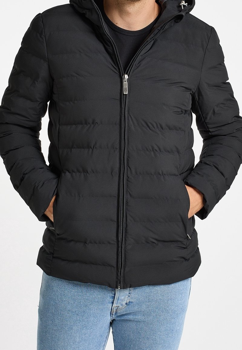 Giubbotto invernale nero con cappuccio, dotato di chiusura con zip, design trapuntato e tasche laterali. Tessuto morbido e vestibilità casual.