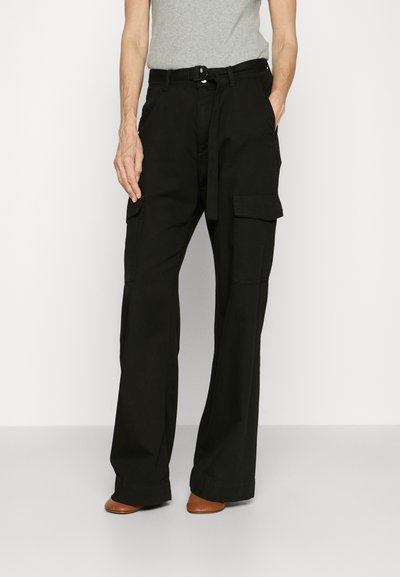 Black cargo pants with a relaxed fit, featuring side pockets and a belted waist. Fabric is smooth with a matte finish.