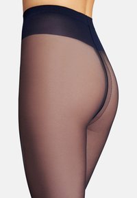 Opake Strumpfhosen mit einer glatten, transparenten nude Oberfläche, einem dunklen Taillenbund und einem nahtlosen Design, das einen Farbverlauf von dunkel nach hell zeigt.