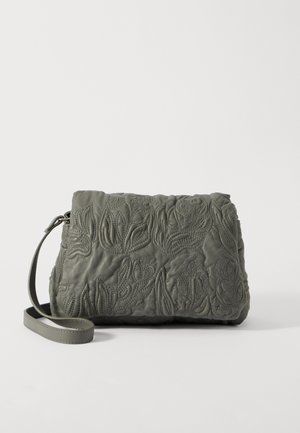 Hallucina nahkakäepael, millel on keeruline lilleline tikand ja kitsas rihm, esitatuna ühtlase valge tausta ees.