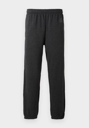 Šedé tepláky vyrobené z měkké tkaniny, s elastickým pasem a tapered nohavicemi s elastickými manžetami. Jemný detail loga na jedné nohavici.