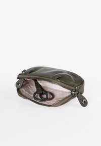 Olijfgroene leren pouch met een gestructureerd oppervlak, voorzien van een ritsluiting en een lichte stofvoering; inclusief twee zwarte sleutelhangers binnenin.