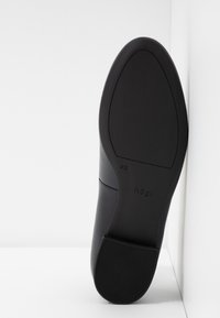 Black leather shoe sole with a smooth finish, featuring a rounded shape and a textured rubber outsole. Brand name "hög" embossed on side.