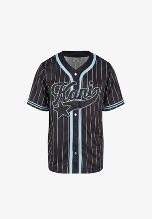 Melnā beisbola krekls ar vertikālām baltām svītrām, gaiši ziliem akcentiem, noapaļotu apkakli un lielu "Kani" logotipu uz priekša.