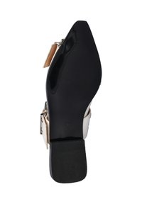 Witte hoge hak schoen met een gladde afwerking, voorzien van een zwarte rubberen zool. Inclusief een gespsluiting aan de zijkant en een puntige neus.