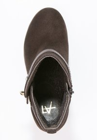 Bruna mockakänga med en slät yta, dragkedjeslutning, metallisk detalj och rundad tå. Insidan har en strukturerad foder.