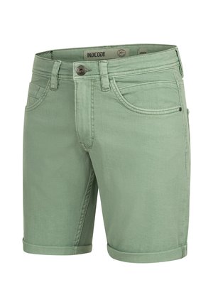 Zöld farmernadrág rövidnadrág, felgöngyölt szegéllyel, öt zsebbel és fém gombzárral. Sima textúra finom varrási részletekkel.