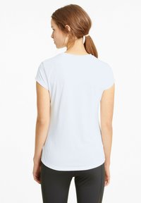 Biała koszulka z krótkim rękawem wykonana z gładkiego, lekkiego materiału, z okrągłym dekoltem i luźnym krojem, widziana z tyłu.