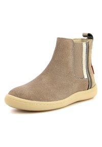 Botín de tobillo beige brillante con paneles elásticos en los laterales, suela en crema y una lengüeta en la parte trasera. Textura suave con acentos metálicos.