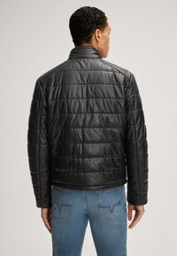 Schwarze gesteppte Lederjacke mit hohem Kragen und langen Ärmeln, mit horizontalen Nähten und glatter Textur. Verstellbarer Saum.