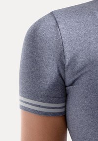 Grå atletisk skjorte med en tætsiddende pasform. Korte ærmer med tre grå striber ved manchetterne. Stoffet har en meleret tekstur.