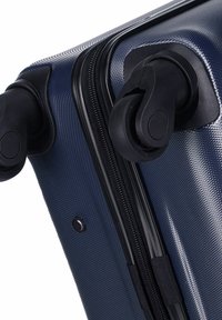 Valigia rigida navy con superficie testurizzata, doppi spinner neri e una robusta chiusura a zip lungo il lato.
