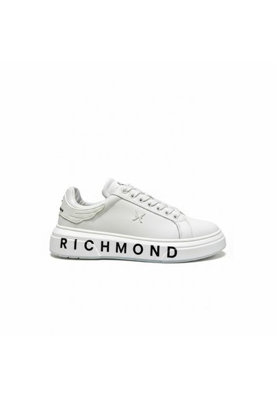 Witte lage sneaker met veters, reliëf van een vleugel bij de hiel en "RICHMOND" in dikke zwarte letters gedrukt op de dikke zool.