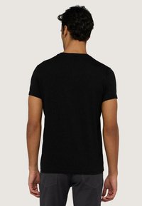 Czarna koszulka z krótkim rękawem i okrągłym dekoltem. Wykonana z bawełny, charakteryzująca się gładką fakturą i klasycznym, dopasowanym krojem bez grafik.