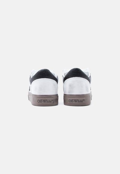 Baskets basses blanches et noires avec des accents en cuir texturé, dotées d'une semelle en caoutchouc grise et du logo "Off-White™" sur le talon.
