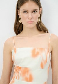 Dresses without sleeves, valkoisella sävyllä, jossa on syksyn oranssit vesivärit, suoran kaula-aukon ja ohuen olkaimen muotoilu. Teksturoitu kangas, jossa on pehmeät laskokset.