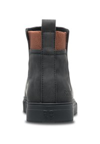 Bota de ankle negra de cuero con panel elástico marrón en la parte superior, tacón texturizado y logo embosado "ROXY" en el costado. Diseño de suela plana.