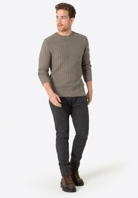 Grauer Strickpullover mit einem strukturierten Muster, kombiniert mit dunkelgrauen Hosen und braunen Schnürstiefeln. Einfaches, lässiges Design.