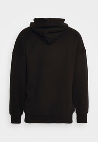 Sudadera negra con un corte relajado, que cuenta con capucha con cordón, hombros caídos y puños y dobladillo acanalados. Textura suave.