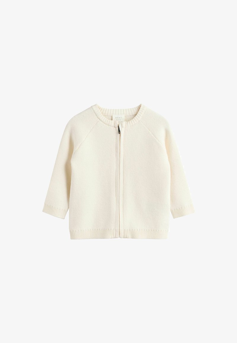 Cardigan pour bébé en tricot couleur crème avec un col rond, fermeture éclair et manches et ourlet côtes. Il présente des manches raglan.