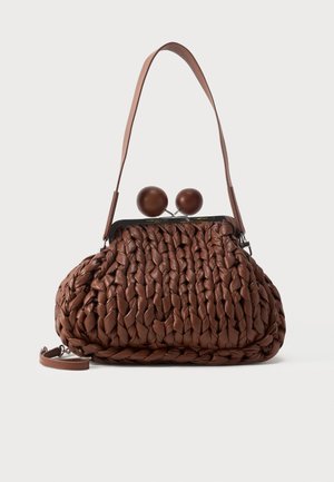 Sac à main en cuir tressé marron avec une seule bandoulière et deux grandes fermetures rondes en bois sur le dessus.